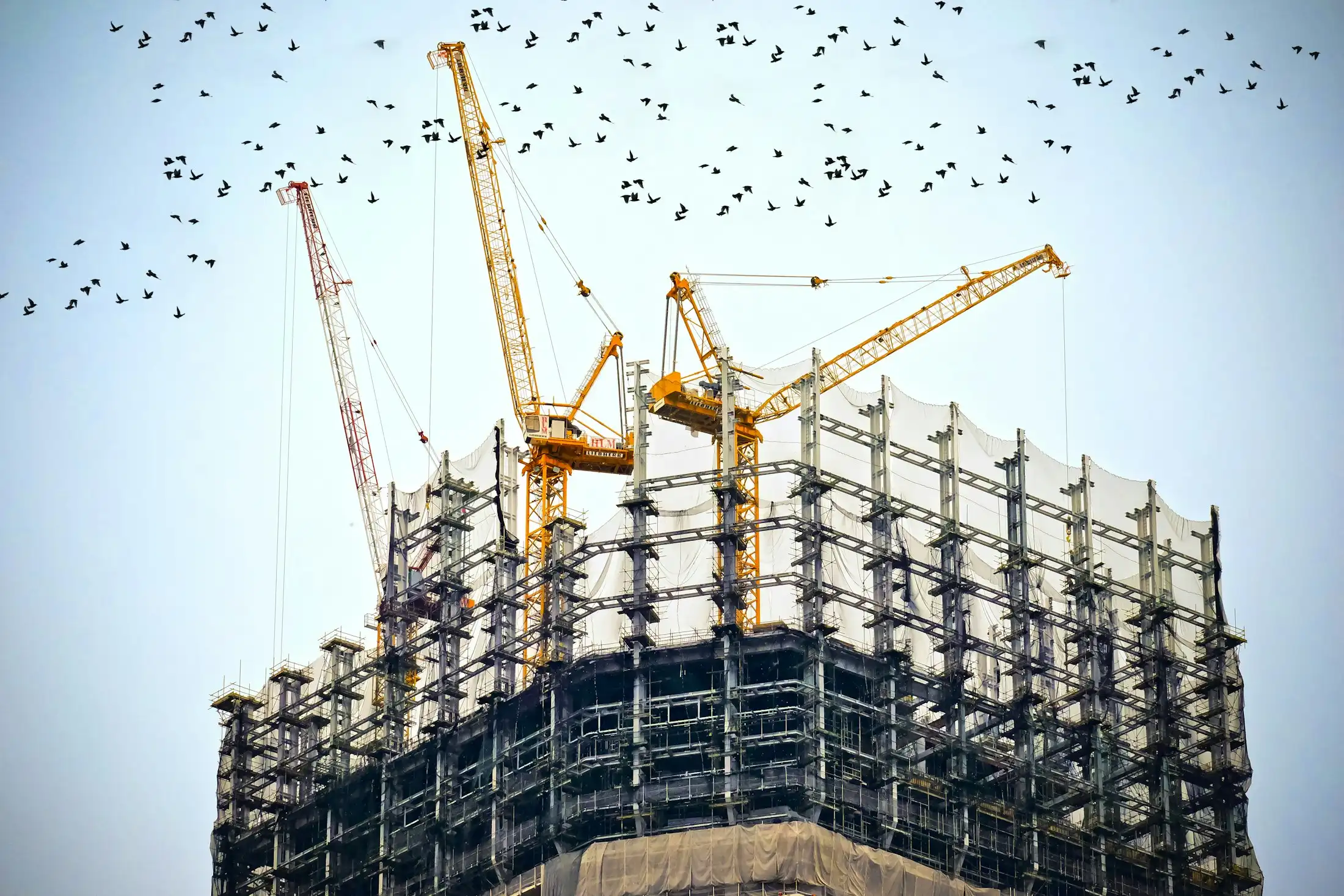 Gedung bertingkat dalam tahap konstruksi dengan tower crane